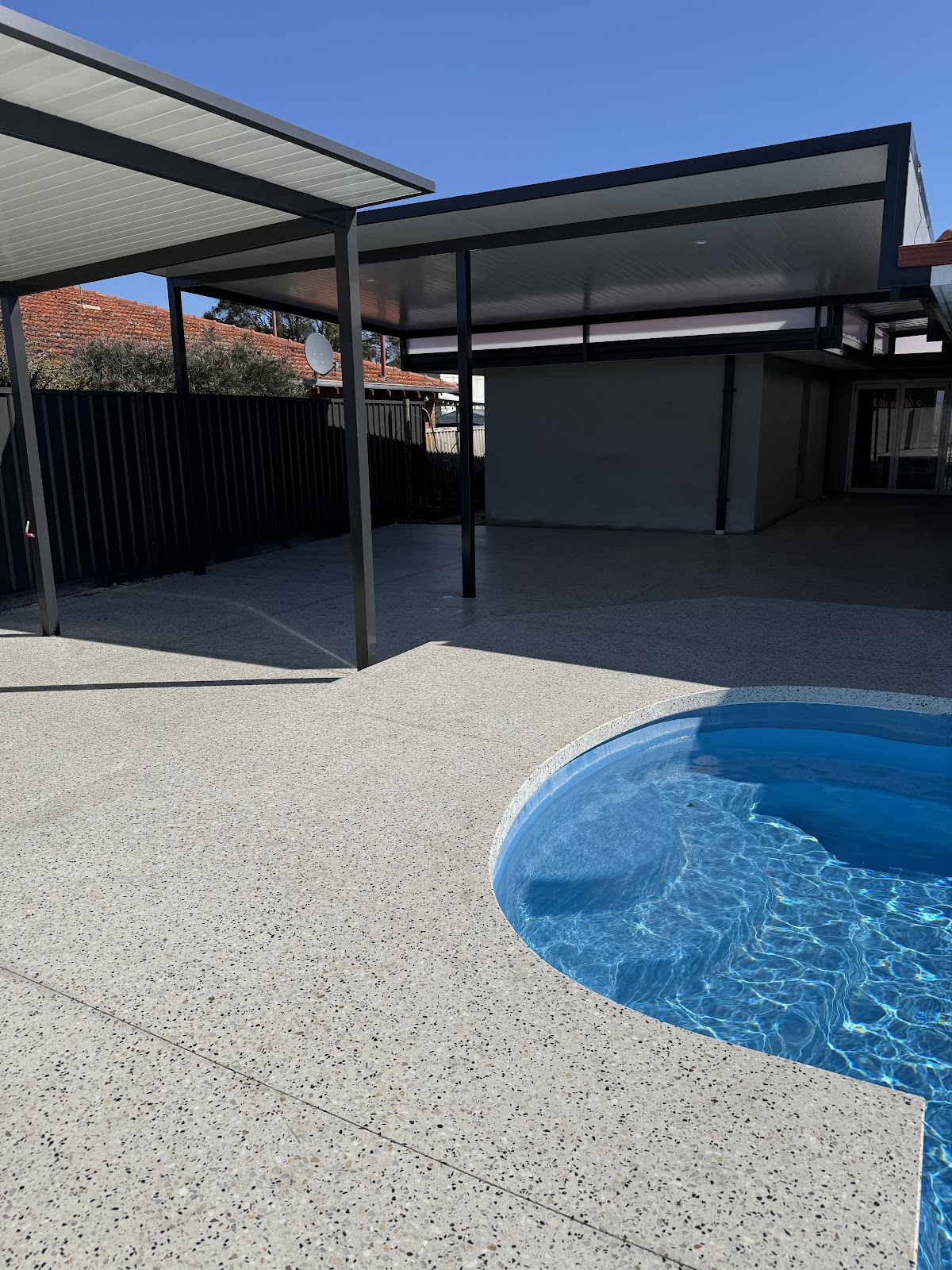 Honed concrete pool surround meeting the patio slab, portrait view