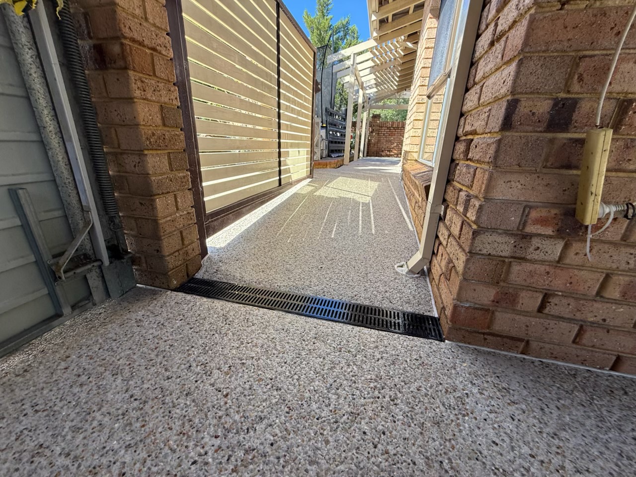 Exposed aggregate side path with a strip drain set flush at the gate