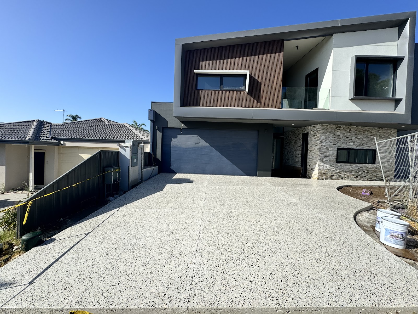 Wide exposed aggregate driveway and crossover at a modern two-storey home
