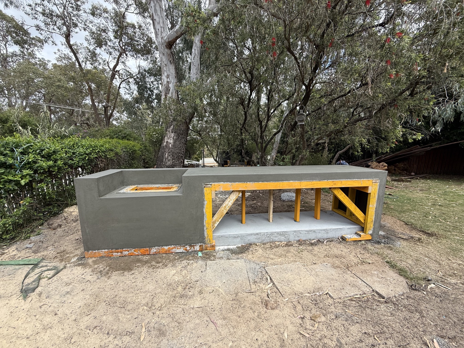 Outdoor kitchen bench during the build, formwork still on, sink cutout and seat cast as one piece